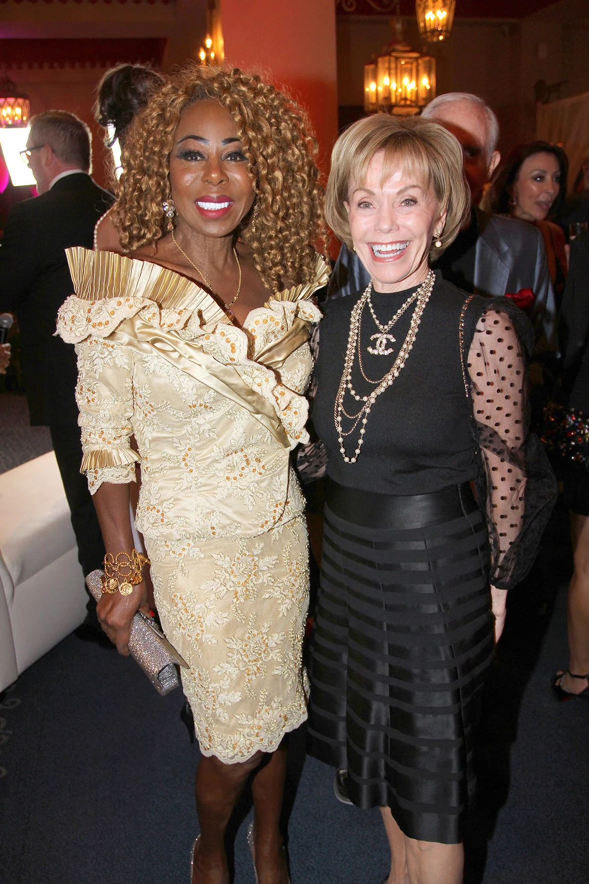 Two guests smiling at an evening reception.