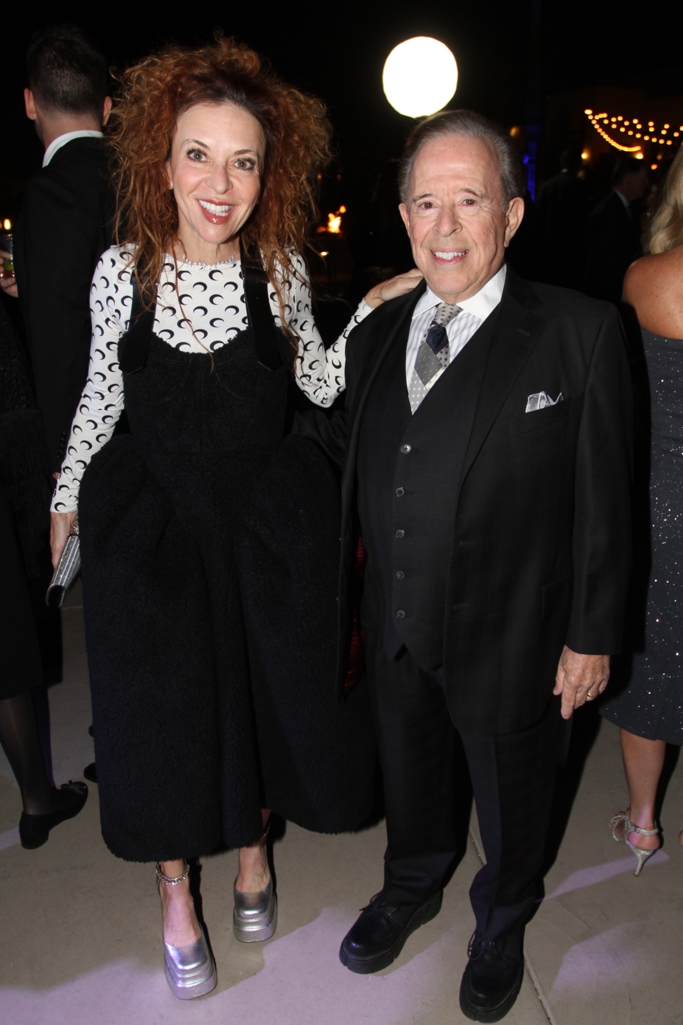 Two guests posing at an evening reception.