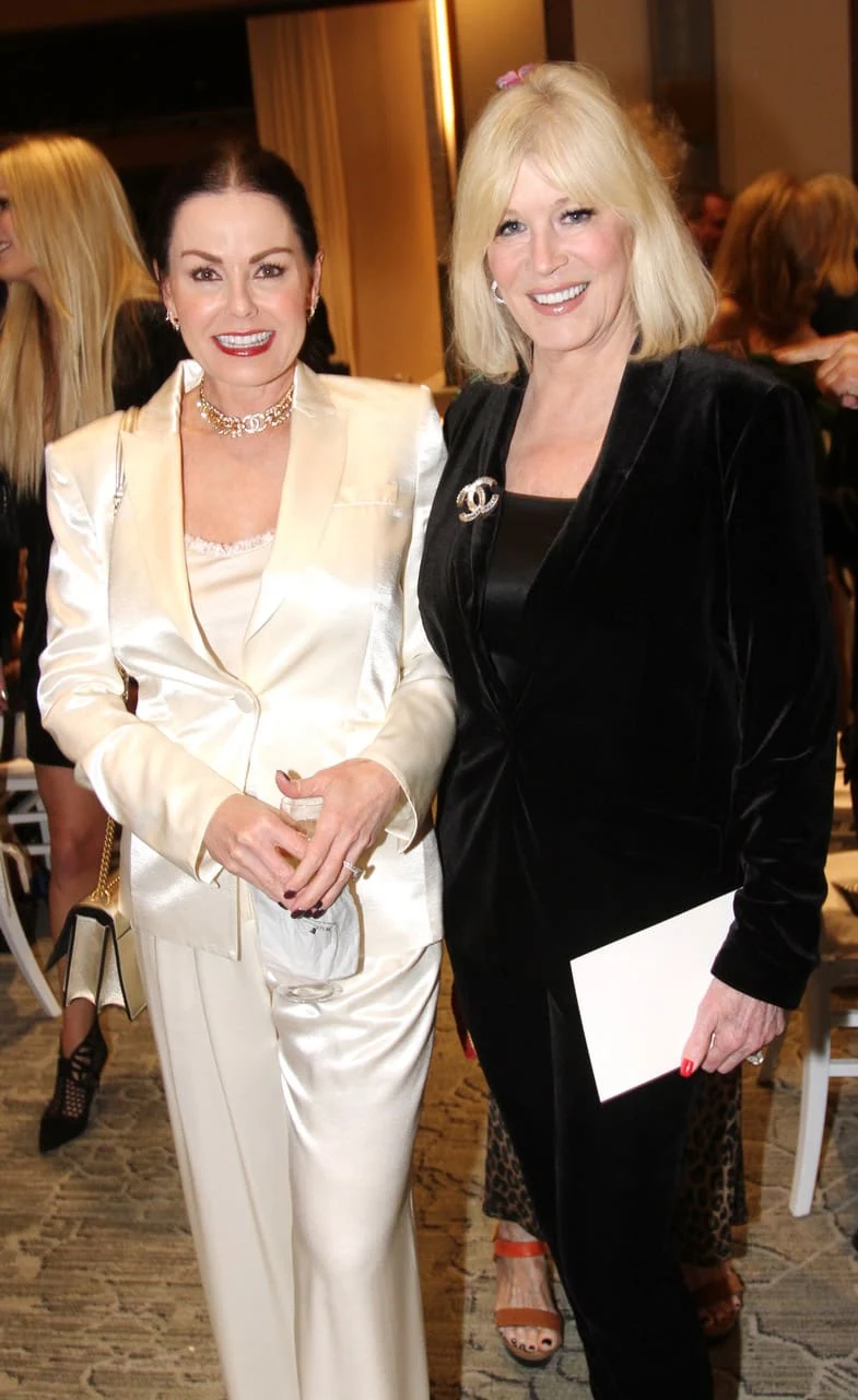 Two guests standing together inside a ballroom.